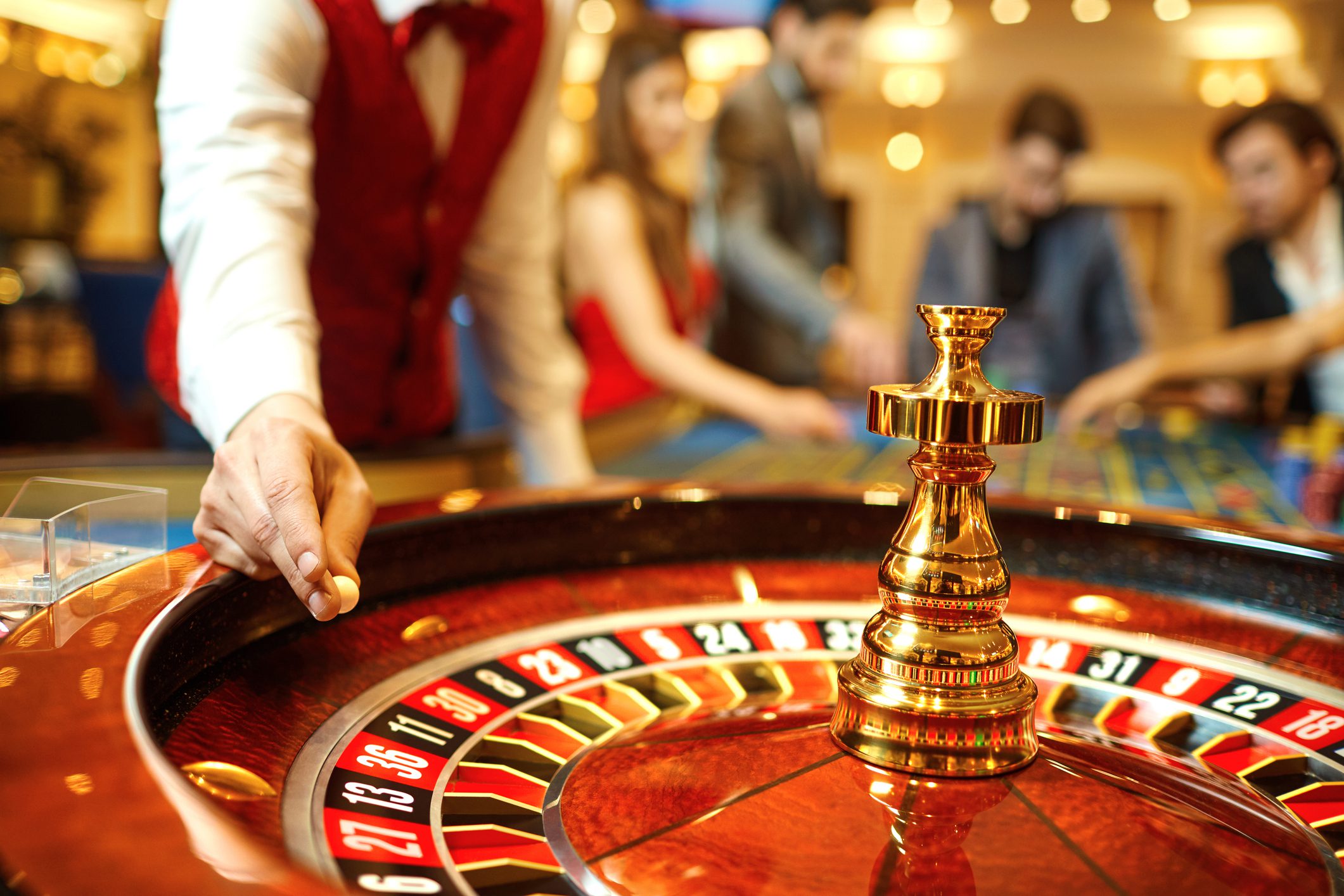 Roulette table with people in background.